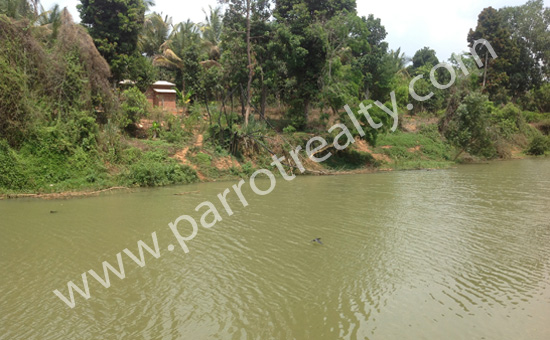 1acre river side land with a small incomplete house in cherukaattoor